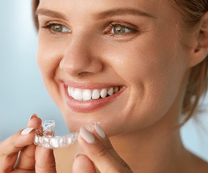 A woman holding her invisalign clear aligners for tooth straightening